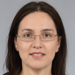 Joyful white adult female with long  brown hair and brown eyes