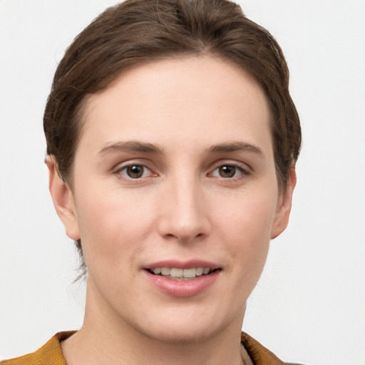 Joyful white young-adult female with short  brown hair and grey eyes