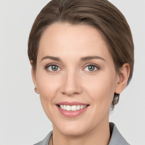 Joyful white young-adult female with medium  brown hair and grey eyes