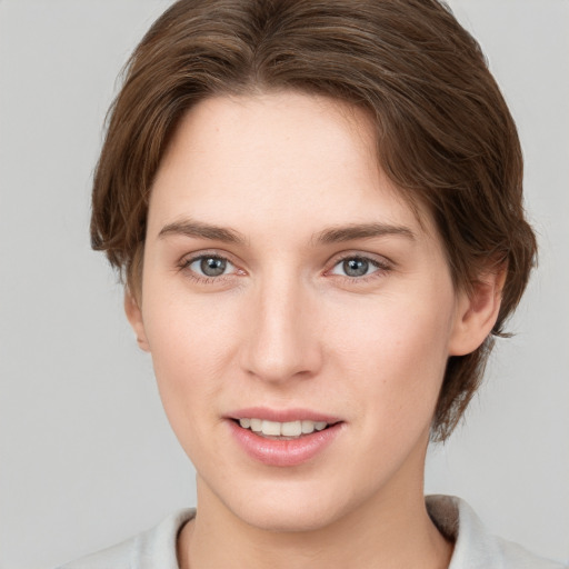 Joyful white young-adult female with short  brown hair and grey eyes