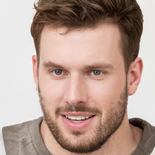 Joyful white young-adult male with short  brown hair and grey eyes