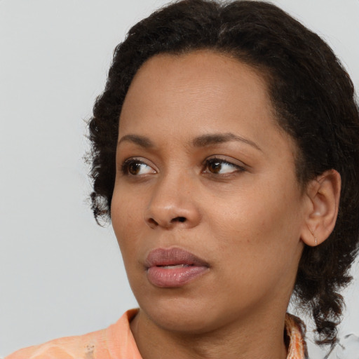 Neutral black young-adult female with medium  brown hair and brown eyes