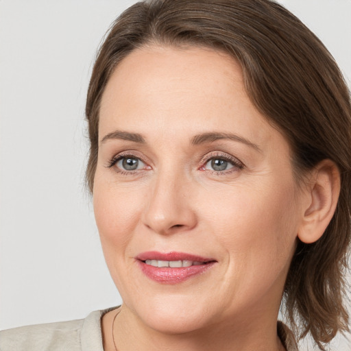 Joyful white adult female with medium  brown hair and grey eyes