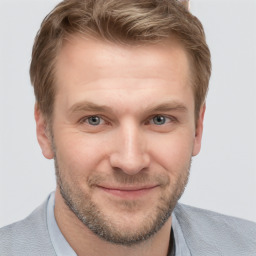 Joyful white young-adult male with short  brown hair and grey eyes