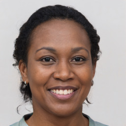 Joyful black adult female with medium  brown hair and brown eyes