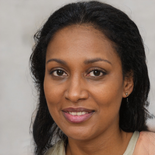 Joyful black adult female with medium  brown hair and brown eyes