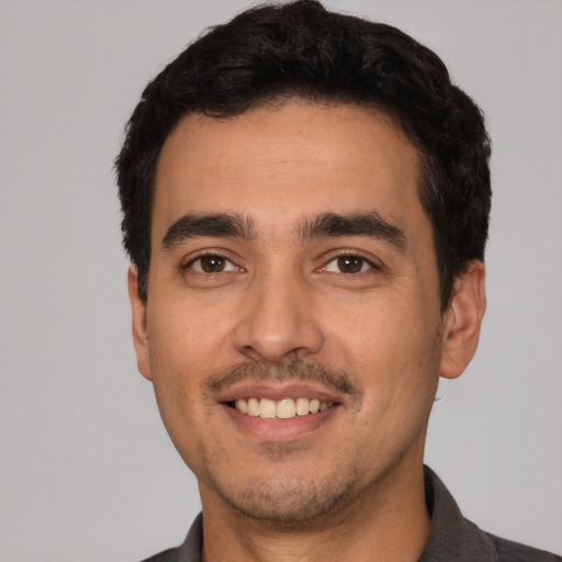 Joyful white young-adult male with short  black hair and brown eyes