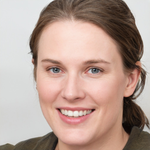 Joyful white young-adult female with medium  brown hair and blue eyes