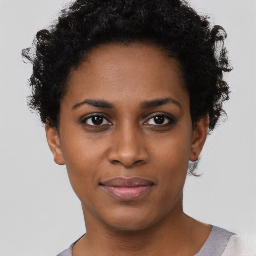 Joyful black young-adult female with short  brown hair and brown eyes