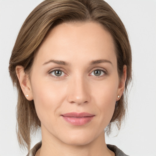 Joyful white young-adult female with medium  brown hair and grey eyes