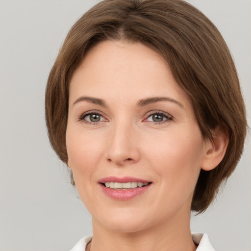 Joyful white young-adult female with medium  brown hair and grey eyes