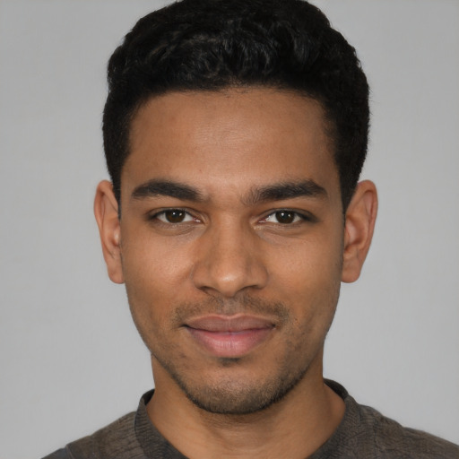 Joyful latino young-adult male with short  black hair and brown eyes