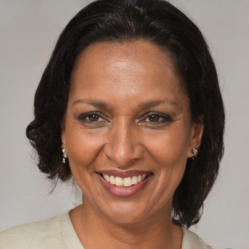 Joyful black adult female with medium  brown hair and brown eyes