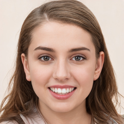 Joyful white young-adult female with long  brown hair and grey eyes