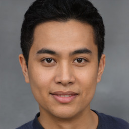 Joyful latino young-adult male with short  brown hair and brown eyes