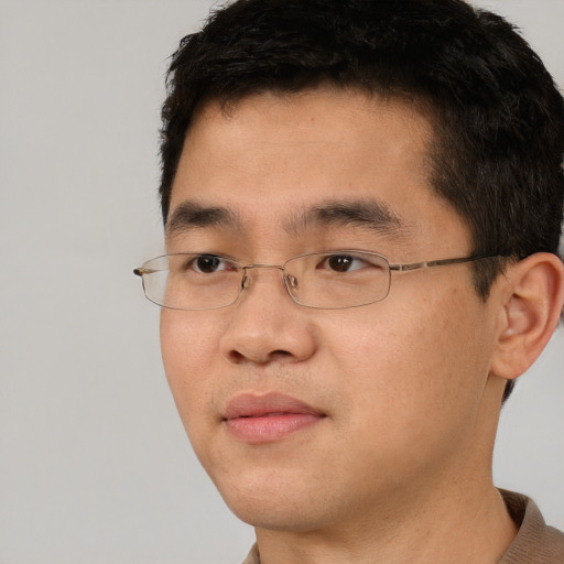 Joyful asian young-adult male with short  brown hair and brown eyes