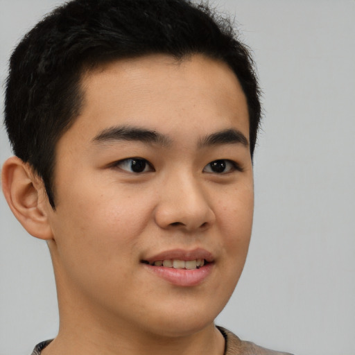 Joyful asian young-adult male with short  brown hair and brown eyes