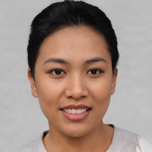 Joyful asian young-adult female with short  black hair and brown eyes