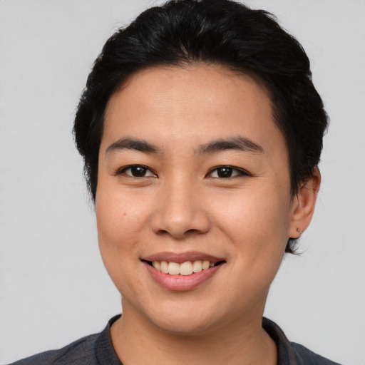 Joyful asian young-adult female with short  black hair and brown eyes