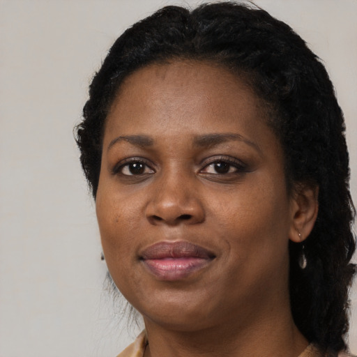 Joyful black adult female with long  black hair and brown eyes