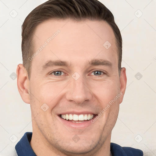 Joyful white young-adult male with short  brown hair and grey eyes