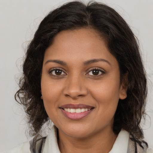 Joyful latino young-adult female with medium  brown hair and brown eyes