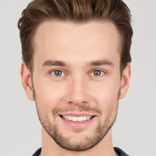 Joyful white young-adult male with short  brown hair and grey eyes