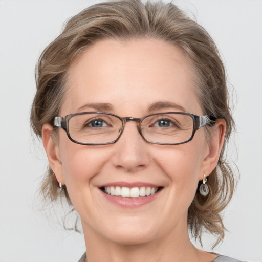 Joyful white adult female with medium  brown hair and blue eyes