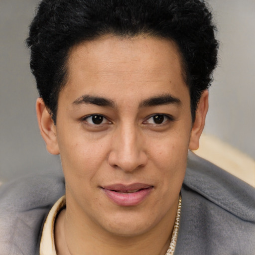 Joyful latino young-adult male with short  brown hair and brown eyes