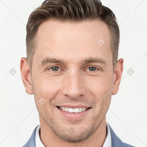 Joyful white young-adult male with short  brown hair and grey eyes