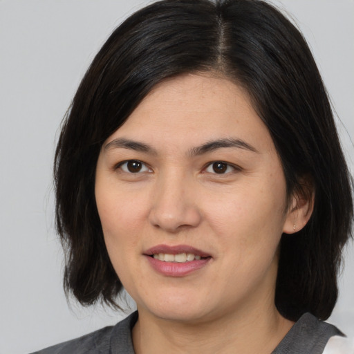 Joyful asian young-adult female with medium  brown hair and brown eyes