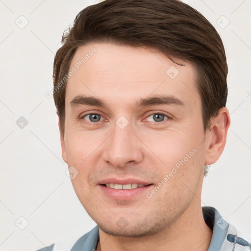 Joyful white young-adult male with short  brown hair and grey eyes