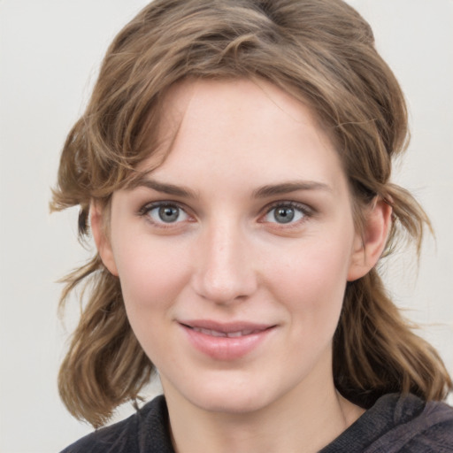 Joyful white young-adult female with medium  brown hair and grey eyes