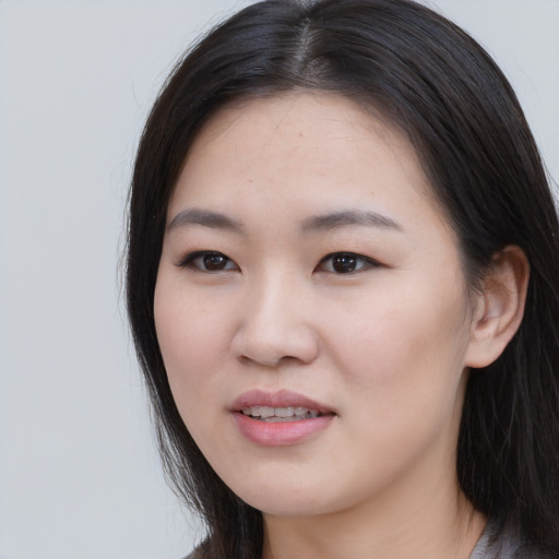 Joyful asian young-adult female with long  black hair and brown eyes