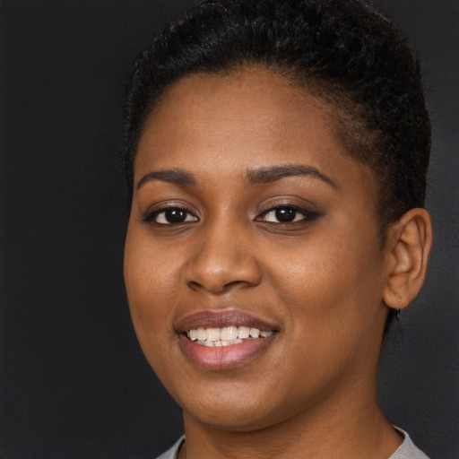 Joyful black young-adult female with long  brown hair and brown eyes