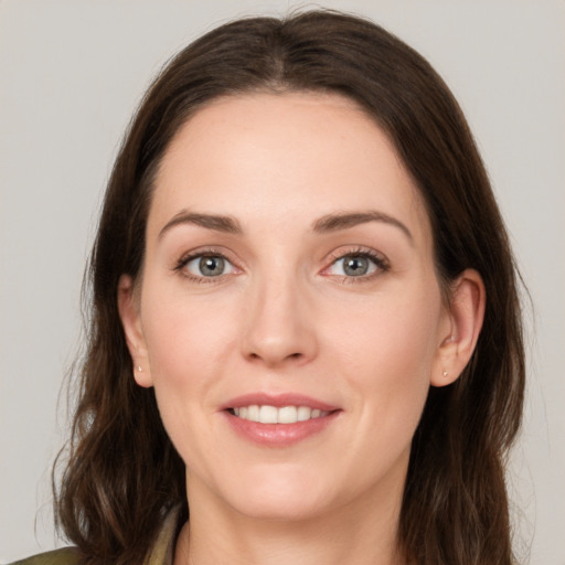 Joyful white young-adult female with medium  brown hair and green eyes