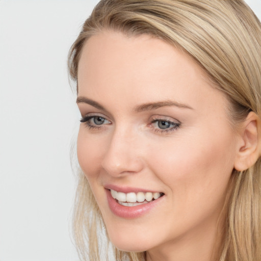 Joyful white young-adult female with long  brown hair and blue eyes