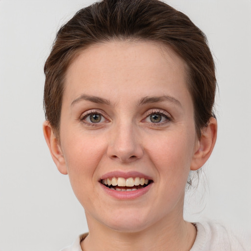 Joyful white young-adult female with short  brown hair and grey eyes