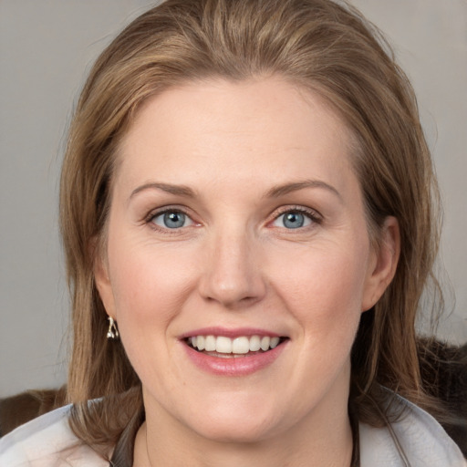 Joyful white young-adult female with medium  brown hair and blue eyes