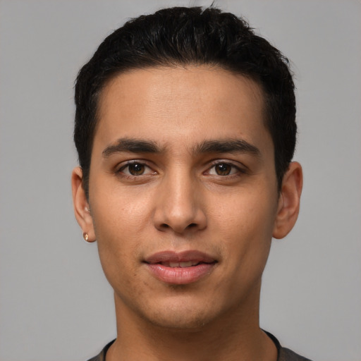 Joyful latino young-adult male with short  black hair and brown eyes