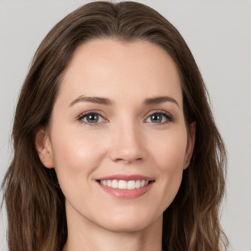 Joyful white young-adult female with long  brown hair and grey eyes