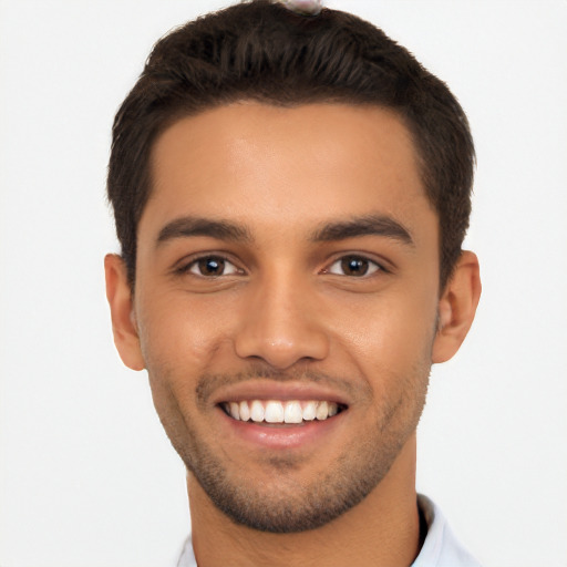 Joyful latino young-adult male with short  brown hair and brown eyes