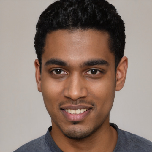 Joyful black young-adult male with short  black hair and brown eyes