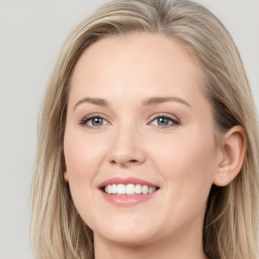 Joyful white young-adult female with long  brown hair and blue eyes