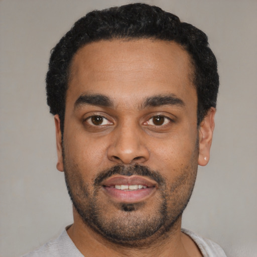 Joyful latino young-adult male with short  black hair and brown eyes