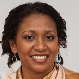 Joyful black adult female with medium  brown hair and brown eyes