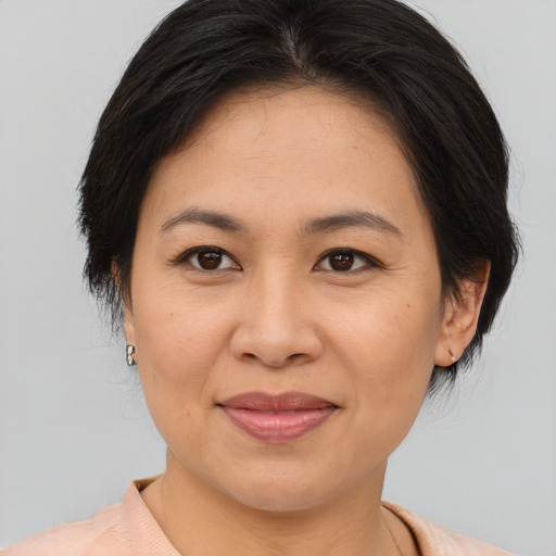 Joyful asian adult female with medium  brown hair and brown eyes