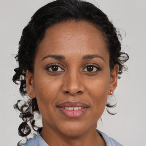 Joyful black adult female with medium  brown hair and brown eyes