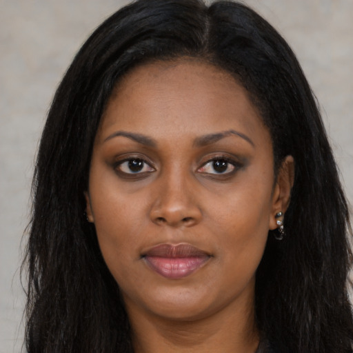 Joyful black young-adult female with long  black hair and brown eyes