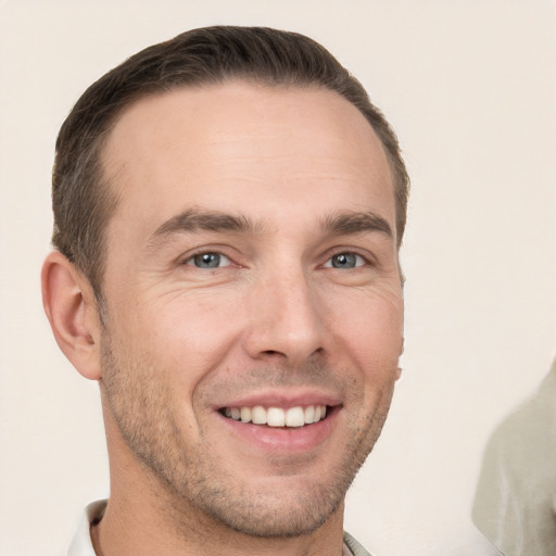 Joyful white young-adult male with short  brown hair and grey eyes